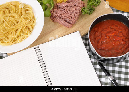 Die Italienische Spaghetti Bolognese mit Zutaten und leere Rezeptbuch oder Kochbuch. Platz für Kopieren. Stockfoto