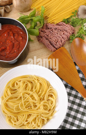 Schüssel Spaghetti mit Bolognese Sauce und Zutaten in den Hintergrund. Stockfoto