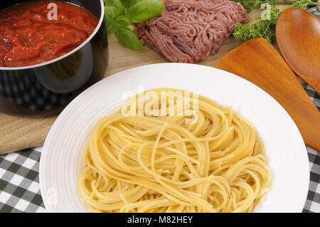 Schüssel Spaghetti mit Bolognese Sauce und Zutaten in den Hintergrund. Stockfoto