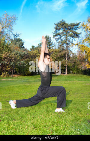 Attraktiven jungen Mann zu tun Übung im Herbst Park Stockfoto