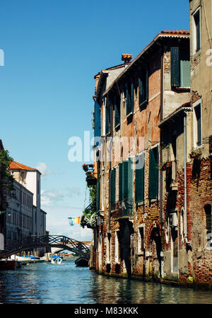 Bunte schmale Seitenkanal, Kirche Santa Maria dei Miracoli und Fußgängerbrücke im Sestiere Cannaregio am Morgen, in Venedig, Italien Stockfoto