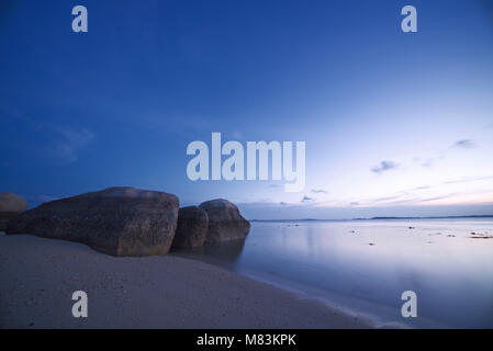 Lange Belichtung Foto der Strand von Cempedak Private Insel mit Felsformationen, Bintan Regency, Riau Inseln, Indonesien, während der Blauen Stunde Stockfoto