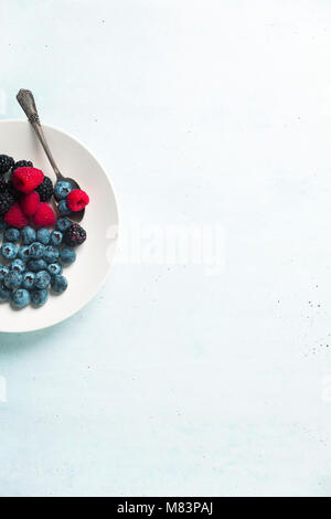 Obst Salat mit verschiedenen frischen Sommer Beeren in weiße Platte. Ansicht von oben Stockfoto