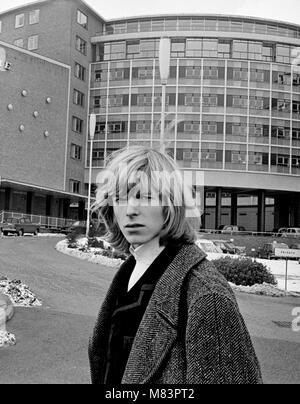 Sänger David Bowie, wenn Er wurde bekannt als Davy Jones, dargestellt außerhalb der BBC Television Centre, wo er und seine Band sind mir zu schade der Narr auf der BBC-Show "Gadzooks! Es ist alles da. Die show Produzent Barry Langford bestand darauf, dass Bowie schnitt seine Haare, die er nicht tun und organisierte Demonstrationen bei der BBC mit Bannern wie "Fair Zu lange Haare'. Die Gruppe wurden später auf die Show mit der Bedingung zu erscheinen, wenn sie Beschwerden, das Band der Liebe gehen würde. Es wurden keine Beschwerden erhalten. März 1965 Stockfoto