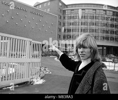 Sänger David Bowie, wenn Er wurde bekannt als Davy Jones, dargestellt außerhalb der BBC Television Centre, wo er und seine Band sind mir zu schade der Narr auf der BBC-Show "Gadzooks! Es ist alles da. Die show Produzent Barry Langford bestand darauf, dass Bowie schnitt seine Haare, die er nicht tun und organisierte Demonstrationen bei der BBC mit Bannern wie "Fair Zu lange Haare'. Die Gruppe wurden später auf die Show mit der Bedingung zu erscheinen, wenn sie Beschwerden, das Band der Liebe gehen würde. Es wurden keine Beschwerden erhalten. März 1965 Stockfoto
