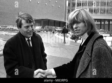 Sänger David Bowie, wenn Er wurde bekannt als Davy Jones, dargestellt außerhalb der BBC Television Centre, wo er und seine Band sind mir zu schade der Narr auf der BBC-Show "Gadzooks! Es ist alles da. Die show Produzent Barry Langford bestand darauf, dass Bowie schnitt seine Haare, die er nicht tun und organisierte Demonstrationen bei der BBC mit Bannern wie "Fair Zu lange Haare'. Die Gruppe wurden später auf die Show mit der Bedingung zu erscheinen, wenn sie Beschwerden, das Band der Liebe gehen würde. Es wurden keine Beschwerden erhalten. März 1965 Stockfoto