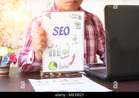 Business Mann mit SEO und Millimeterpapier auf die Relation und verwenden Computer suchen Stockfoto