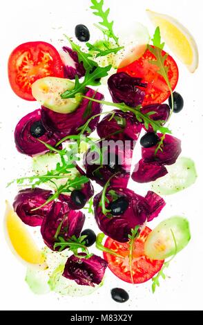 Frischer Salat mit grünen, Tomaten, Oliven und in Scheiben geschnittene Gurken isoliert auf weißem Stockfoto