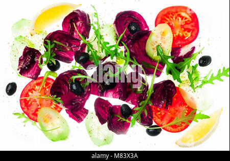 Frischer Salat mit grünen, Tomaten, Oliven und in Scheiben geschnittene Gurken isoliert auf weißem Stockfoto