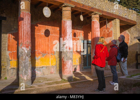 Herculaneum römisches Haus, Besucher der antiken römischen Stadt Herculaneum (Ercolano) Studie die Ruinen der Casa dei Cervi, Villa eines römischen Adligen. Stockfoto