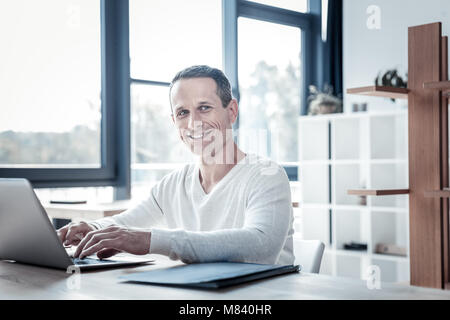 Erfolgreiche qualifizierten Mann lächelnd und mit dem Laptop. Stockfoto