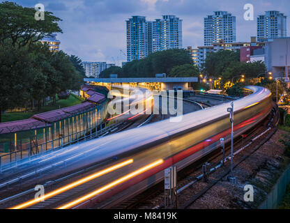 Mass Rapid Transit (MRT), Ang Mo Kio station in Singapur. Das Bild wurde nach dem Sonnenuntergang und verfügt über Züge Kreuzung mit Bewegungsunschärfe. Stockfoto