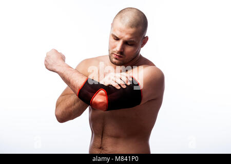 Verletzungen des Ellbogens. Junge glatzköpfige Mann sportlicher Körperbau hält eine kranke Ellbogen in der Armlehne auf weißem Hintergrund isoliert Stockfoto