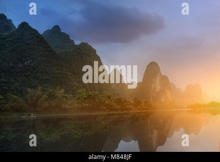 Ein Blick auf die Morgendämmerung am Ufer eines ruhigen Fluss. Stockfoto