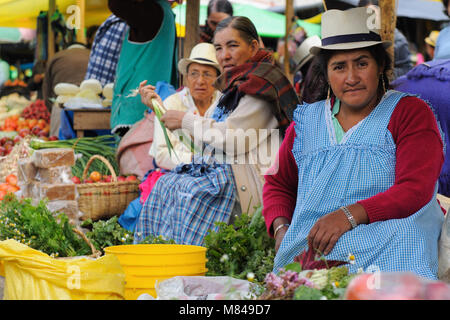 ECUADOR, GUALACEO - 22. AUGUST 2012; Indigenen ecuadorianischen Frauen in Nationale Kleidung Verkauf von landwirtschaftlichen Erzeugnissen und andere Lebensmittel auf einem Markt in Stockfoto