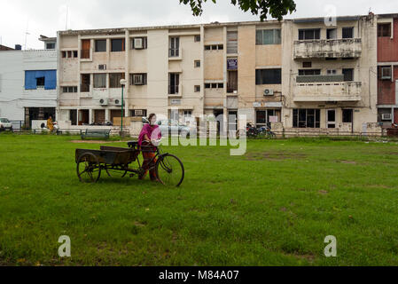 Chandigarh, Indien: Ein indisches Mädchen überquert einen Garten vor einem Gebäude in einer beliebten Gegend von Chandigarh, Indien. Stockfoto