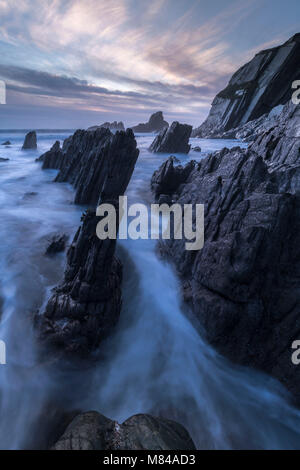 Dämmerung über die dramatischen Felsen von Ayrmer Cove, South Hams, Devon, England. Im Winter (Januar) 2018 Stockfoto