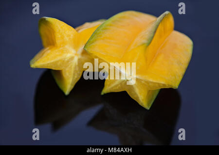 Exotischen starfruit oder averrhoa Carambola siced auf einer schwarzen Platte Stockfoto