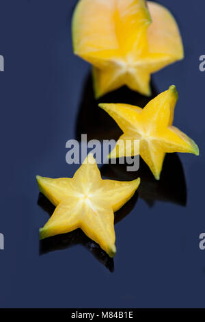 Exotischen starfruit oder averrhoa Carambola siced auf einer schwarzen Platte Stockfoto