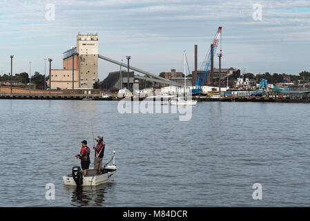 Zwei Männer in einem kleinen Boot (ein BLECHERNER) im Hafen von Sydney in der Nähe von White Bay. Im Hintergrund ist das Glebe Insel Silos, trockenen Zement gedrückt halten. Stockfoto