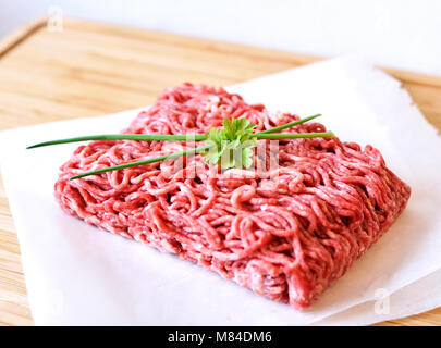 Rohes Hackfleisch oder Rindfleisch auf einer hölzernen Schneidebrett. Frisches Fleisch, kochen Zutat. hoher Blickwinkel betrachten. Stockfoto