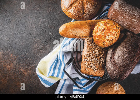 Auswahl an frischen, hausgemachten Korn Brot, in einem Metallkorb, dunkle rusty Background Copy space Stockfoto