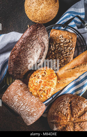 Auswahl an frischen, hausgemachten Korn Brot, in einem Metallkorb, dunkle rusty Background Copy space Top View Stockfoto