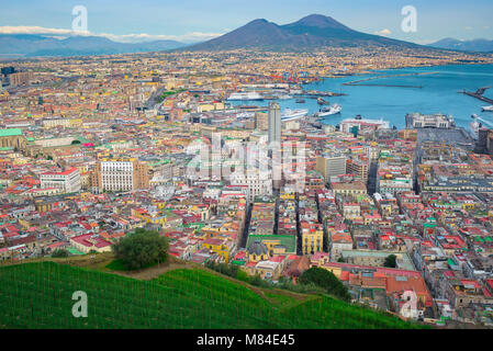 Bucht von Neapel, aus der Vogelperspektive aus dem Stadtteil Vomero der Stadt und Hafen von Neapel mit der majestätischen Form des Vesuvs im Hintergrund, Italien. Stockfoto