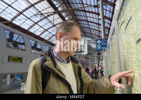 Pkw suchen den Zug in den Zeitplan auf dem zentralen Bahnhof von Antwerpen, Belgien Stockfoto