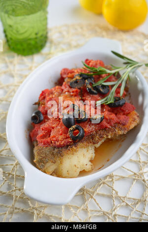 Gebackener Kabeljau unter Tomatensauce mit Oliven Stockfoto