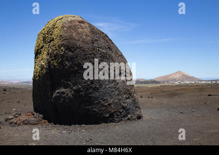 Große vulkanische Bombe, Lanzarote, Vulkankegel im Hintergrund Stockfoto