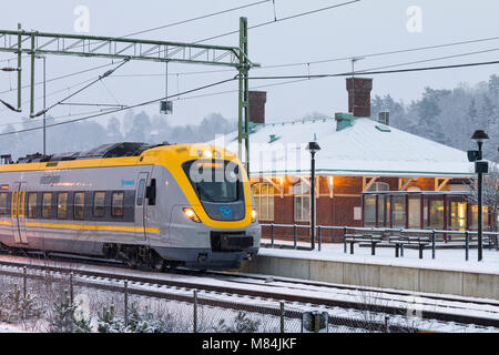 Auch, Schweden - 16. Februar: Moderne Commuter Rail Passenger Zug oder S-Bahn am Bahnhof im Schnee im Winter Model Release: Nein Property Release: Nein. Stockfoto