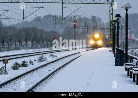 Auch, Schweden - 16. Februar: Moderne Commuter Rail Passenger Zug oder S-Bahn im Schnee im Winter nähert sich Bahnhof Model Release: Nein Property Release: Nein. Stockfoto