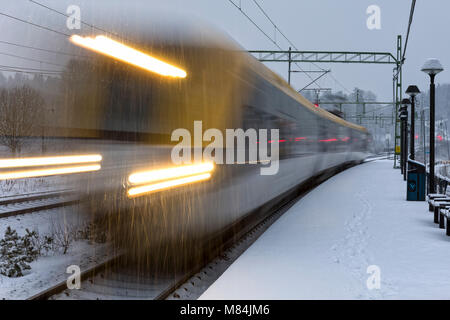 Auch, Schweden - 16. Februar: Moderne Commuter Rail Passenger Zug oder S-Bahn im Schnee im Winter nähert sich Bahnhof Model Release: Nein Property Release: Nein. Stockfoto