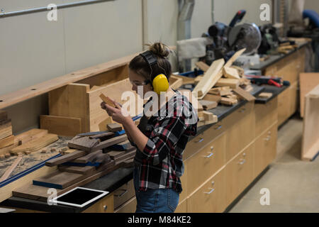 Frau Carpenter Prüfung ein Stück Holz Stockfoto