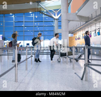 Pendler stehen in der Warteschlange für Check-in Stockfoto