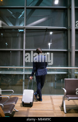 Unternehmer im Wartebereich am Flughafen warten Stockfoto