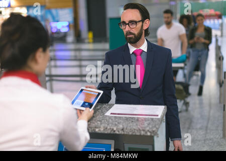 Airline Check-in Telefonzentrale prüfen Ticket für Pendler auf digitalen Tablet Stockfoto