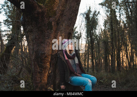 Frau sitzt unter einem Baum Stockfoto