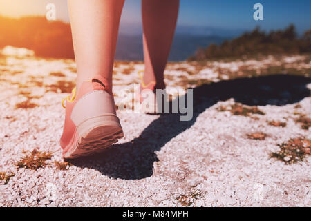 Weibliche Athleten Wandern auf dem felsigen Weg. Junge Frau mit sportlichen sneakers Joggen oder Laufen in der Natur im Freien. Gesunder Lebensstil Konzept Ton Stockfoto