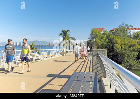 Touristen Kreuz eine Fußgängerbrücke in Puerto Vallarta, Mexiko. Stockfoto