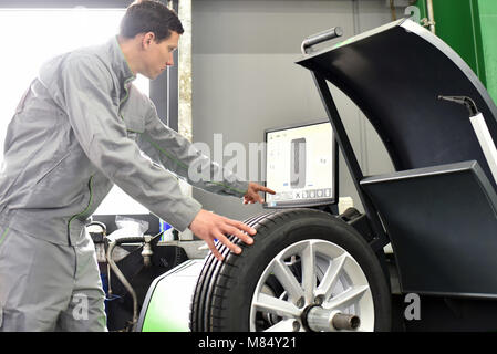 Reifenwechsel in einer Garage - Assembler Auswuchten von Reifen auf der Maschine Stockfoto