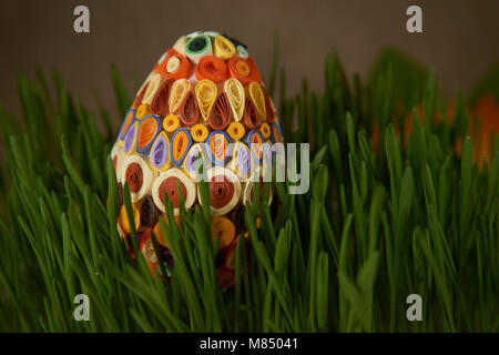 Ostern Handwerk Ideen. Die Ostereier mit bunten Papier eingerichtet, zwischen frech grün Weizenkeime platziert. Stockfoto