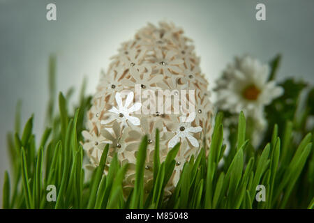 Ostern Handwerk Ideen. Die Ostereier mit weißem Papier Blumen, zwischen frech grün Weizenkeime platziert eingerichtet. Stockfoto