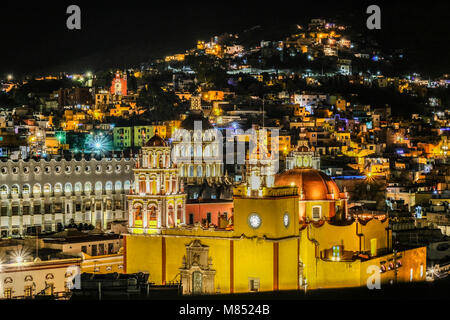 Eine Nacht Blick von oben von Bacilica Unserer Lieben Frau von Guanajuato, der Universität von Guanajuato, und die Lichter von Häusern am Hang Stockfoto