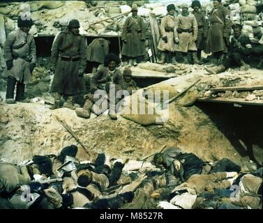 Koloriertes Foto von russischen Soldaten, die in einem Graben über den Leichen toter japanischer Soldaten während des Russisch-Japanischen Krieges standen, 1905. (Foto von Burton Holmes) Stockfoto