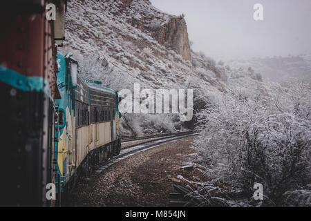 Zug Passagier Perspektive der Wicklung Verde Canyon Railroad mit Schnee, die Bäume und die Felsformationen der Verde Canyon, in der Nähe von Ludlow, Stockfoto