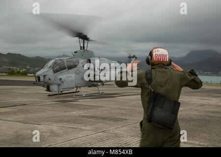 Us Marine Cpl. Austin Rudesill Taxis eine AH-1W Super Cobra Hubschrauber von einem Flug Linie auf Marine Corps Base Hawaii, 13. März 2018. Die AH-1Ws für das letzte Mal auf Hawaii geflogen wurden von der Marine Light Attack Helicopter Squadron 367, in den Ruhestand zu treten. Rudesill, ein Eingeborener von Rosemount, Minnesota, ist ein Flugzeug Kapitän mit HMLA-367, Marine Flugzeuge Gruppe 24. (U.S. Marine Corps Foto von Sgt. Kathy Nunez) Stockfoto