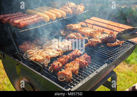 Verschiedene leckere Grillfleisch über die Kohlen auf einem Grill Stockfoto