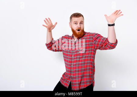 Portrait von Stattlichen glücklicher Mann mit roten Haaren und Bart in Plaid Shirt gegen weiße Wand Stockfoto